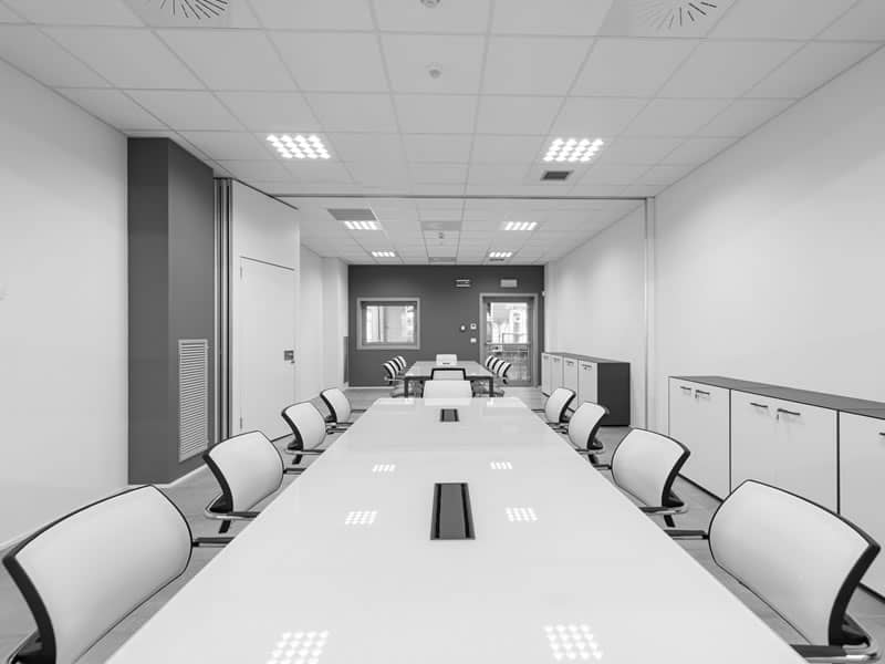ufficio direzionale con tavoli e sede bianche, foto in bianco e nero