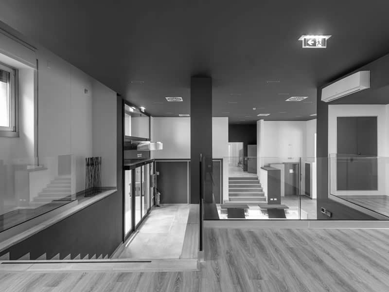edificio commerciale interno ristrutturato con parquet, foto in bianco e nero